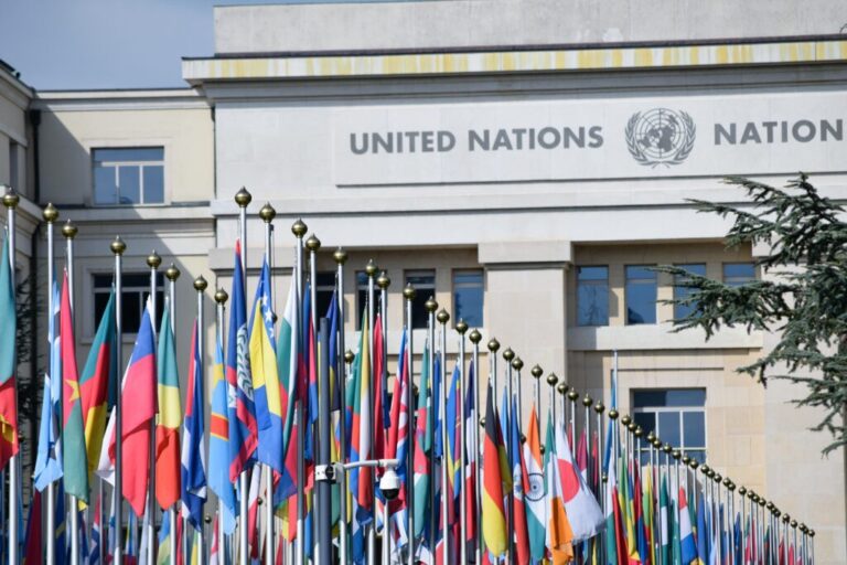 image shows UN building with flags waving